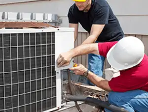 HVAC technicians repairing an outdoor AC unit on a rooftop in Andover, MA